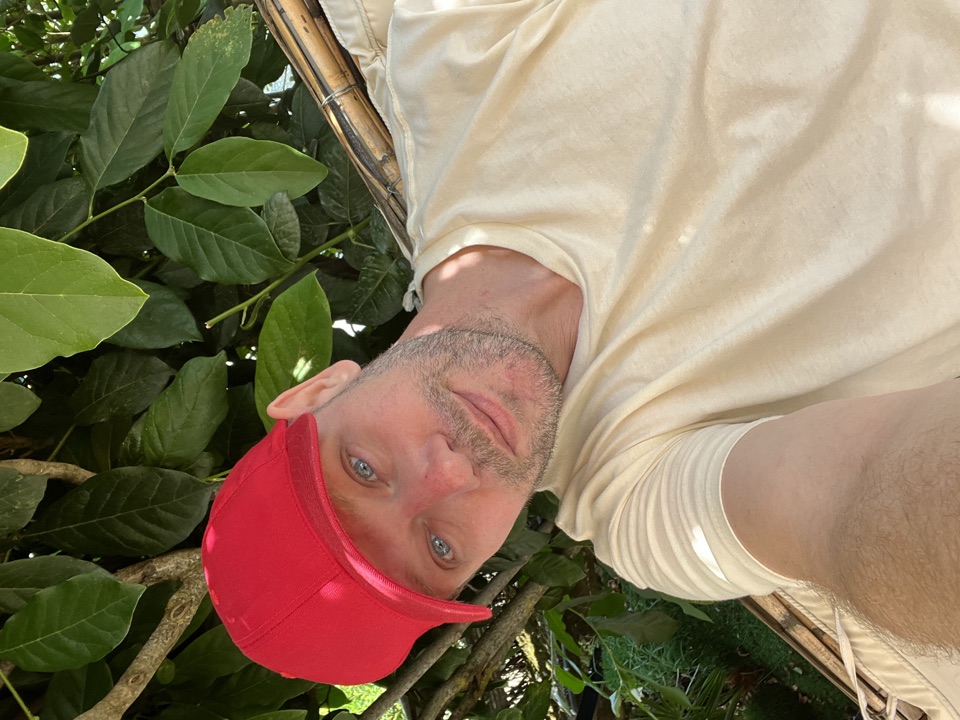 Mikael, the person behind BitSize.me, relaxing outdoors in a red cap.
